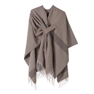 Detailaufnahme des eleganten braunen Damenponchos mit stilvollem Bindegürtel und Fransen.