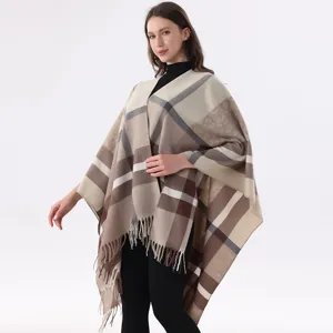 Detailed view of the stylish plaid fringe cape showcasing soft fabric and elegant drape.
