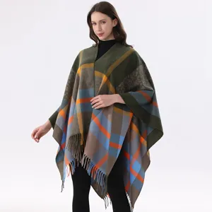 Detailed view of cozy woolen plaid cape with leopard print accents and chic fringe tassels.