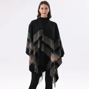 Close-up view of the cozy color-blocked striped cape showing exquisite fringe and knit texture.