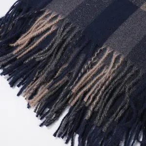 Close-up detail of women's warm striped plaid scarf with decorative fringe texture.