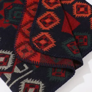 Detailed shot of a classic geometric color-block cashmere-feel shawl blanket with whipstitched edges.