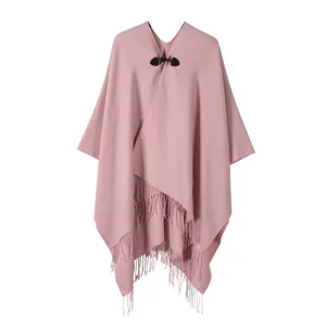 Chic cape poncho en tricot rose avec fermeture a bouton et franges pour l'automne hiver.