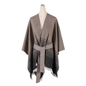 Women's striped knit cape poncho with belt and fringe detail, stylish outer wear for fall.
