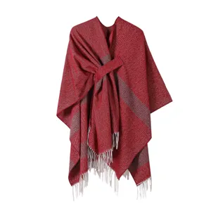 Detailaufnahme des roten Strick-Umhangs mit grauen Streifen und eleganten Fransen am Saum.