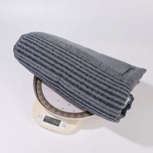 Detail view of women's striped cape shawl, soft knit fabric texture, folded product display.