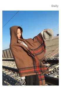 Detailed view of the plaid hooded tassel cape, showcasing warm fabric and cozy outdoor scene.