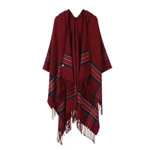 Detailed view of the red hooded plaid cape showing cozy tassel hem and classic striped pattern.