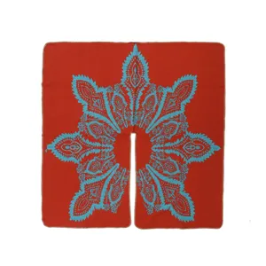 Detalle cercano de la capa étnica roja con patrón de cachemira turquesa para viajes.