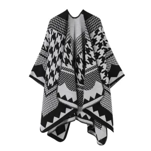 Nahaufnahme des schwarz-weißen Hahnentritt-Strickponchos mit ethnischen geometrischen Mustern.