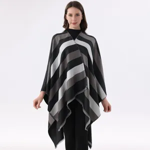 Detailed view of the stylish striped knitted cape shawl, comfortable autumn winter outerwear.