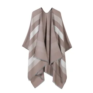 Detailed view of women's cozy knit striped cape shawl with elegant tassel hem for autumn.