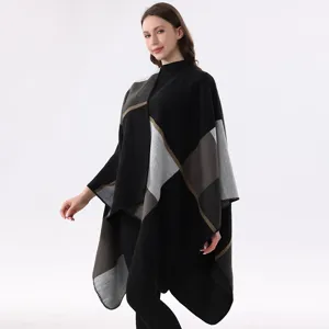 Detailansicht zeigt die weiche Stricktextur und das asymmetrische Farbblock-Design des Umhangs.
