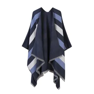 Women's blue striped knitted poncho cape with fringe detail, cozy autumn winter outerwear.