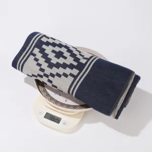 Nahaufnahme eines gemusterten Strickschals gerollt auf Waage, Gewichtsanzeige ca. 482g