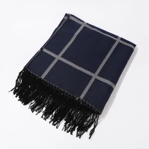 Vista detallada del elegante chal de cuadros azul marino con rejilla gris y flecos negros.