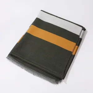 Closeup of the striped reversible winter scarf showing detailed green, white and yellow texture.