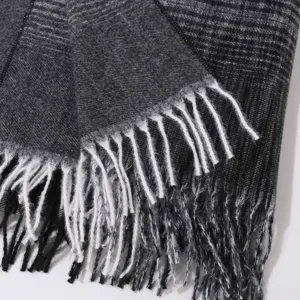 Close-up detail of gradient fringed shawl scarf showing soft knitted texture and fringes.