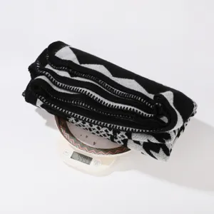 Verdichteter schwarz-weißer Strickschal und Umhang im Detail mit Gewichtsangabe für Damen.