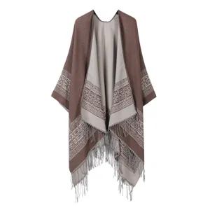 Nahaufnahme des Strick-Fransenponchos mit geometrischer Bordüre und weicher Textur.