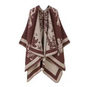 Detailopname van de gebreide cape met zachte textuur, retro bloemenpatroon en nette rand.