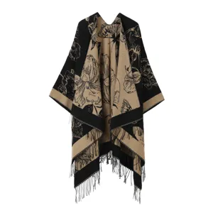 Dettaglio del poncho lavorato a maglia con motivo floreale e farfalla, elegante con frange.