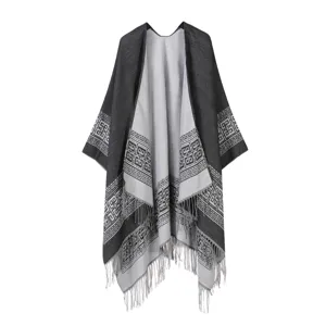 Detailansicht des schwarzgrauen geometrischen Strickponchos mit Fransen am Saum.