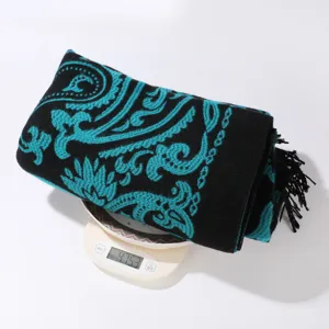 Detailaufnahme eines schwarz-türkisen Kaschmirschals mit Paisley-Muster und Fransen.