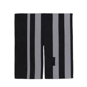 Detailansicht des schwarz-grau gestreiften Cape mit Schlitz und modernen Farbblock-Akzenten.