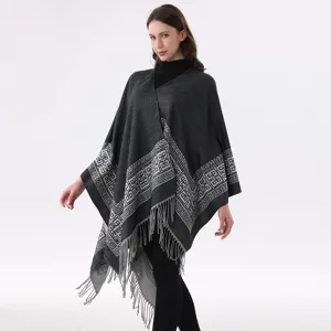 Nahaufnahme des geometrisch gemusterten Strickponchos mit stilvollem Fransen-Saum.