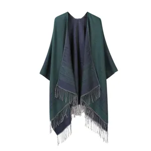 Detailansicht des geometrischen Damen Wendeponchos mit Fransen in Dunkelgrün und Marineblau.