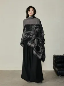 Vista dettagliata della mantella scialle in maglia jacquard artistica con trame eleganti.