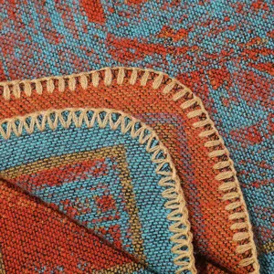 Detailopname van etnisch gebreide deken met kleurrijk geometrisch patroon en randen.