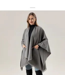 Nahaufnahme des eleganten grauen Damen-Ponchos mit praktischen Taschen und Fransen.