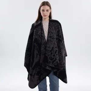 Detailaufnahme des eleganten schwarz-grauen Strick-Capes mit retro-künstlerischen Mustern.