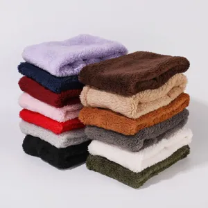 Detail shot showing a neat stack of soft plush winter neck warmers in various solid colors.