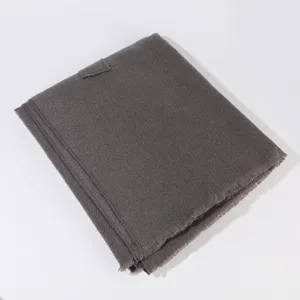 Detailed view of the dark grey knitted winter shawl with side strap and fringed hem details.