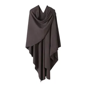 Detailed view of the dark brown knitted cape shawl, featuring soft core-spun yarn and split design.