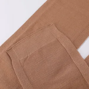 Nahaufnahme eines weichen braunen Strickschals mit feiner Textur und sauberer Nahtverarbeitung.