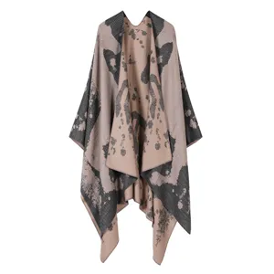 Detailed view of stylish knitted cape shawl featuring an elegant abstract pattern and cozy drape.