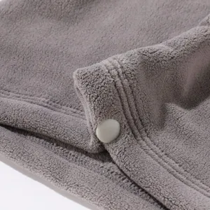 Detalle calentador de cuello invierno de polar gris, tela suave y elástica con botón.