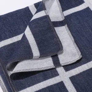 Close-up detail view of the blue and white grid plaid scarf fabric texture and neat edge.