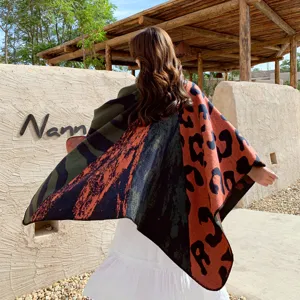 Detailed view of the autumn winter color block knitted cape shawl showing back style outdoors.