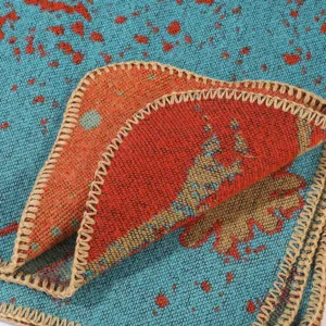 Detail shot of a blue and orange knit shawl scarf with stylish whipstitch edge design.