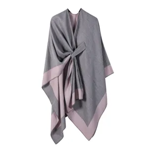 Detailansicht des grauen und rosa Strick-Ponchos für Damen mit elegantem Drapierungs-Design.
