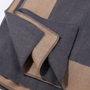 Detailaufnahme einer kuscheligen zweifarbigen Decken-Schal mit feinen sauberen Nähten.