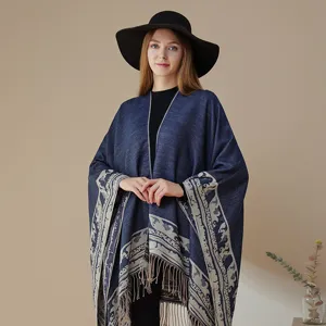 Nahaufnahme der ethnischen Muster und Fransen am eleganten dunkelblauen Strickponcho.