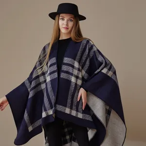 Cozy blue plaid knitted cape for women, stylish double-sided winter poncho shawl.