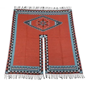 Close-up detail of bohemian ethnic style woven poncho cape with geometric patterns and fringe.
