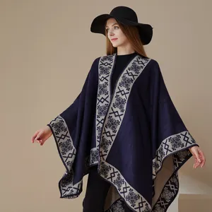 Winter women's poncho cape detail, dark blue fabric with beige geometric patterned border.